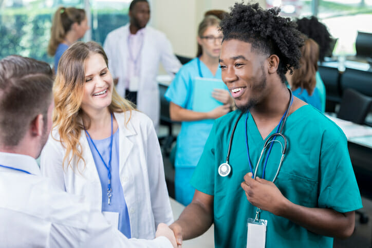 Why is onboarding important in healthcare? A group of medical professionals shake hands
