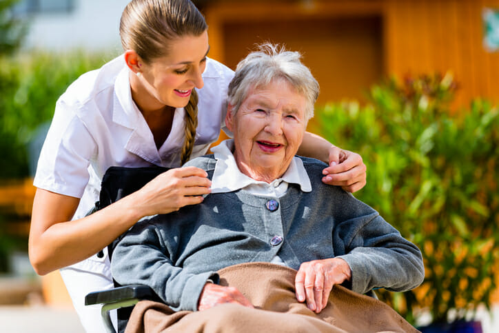 Rural nursing. A young nurse and an older woman using a wheelchair laugh together.