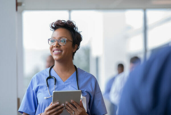A healthcare worker looks out a window and smiles