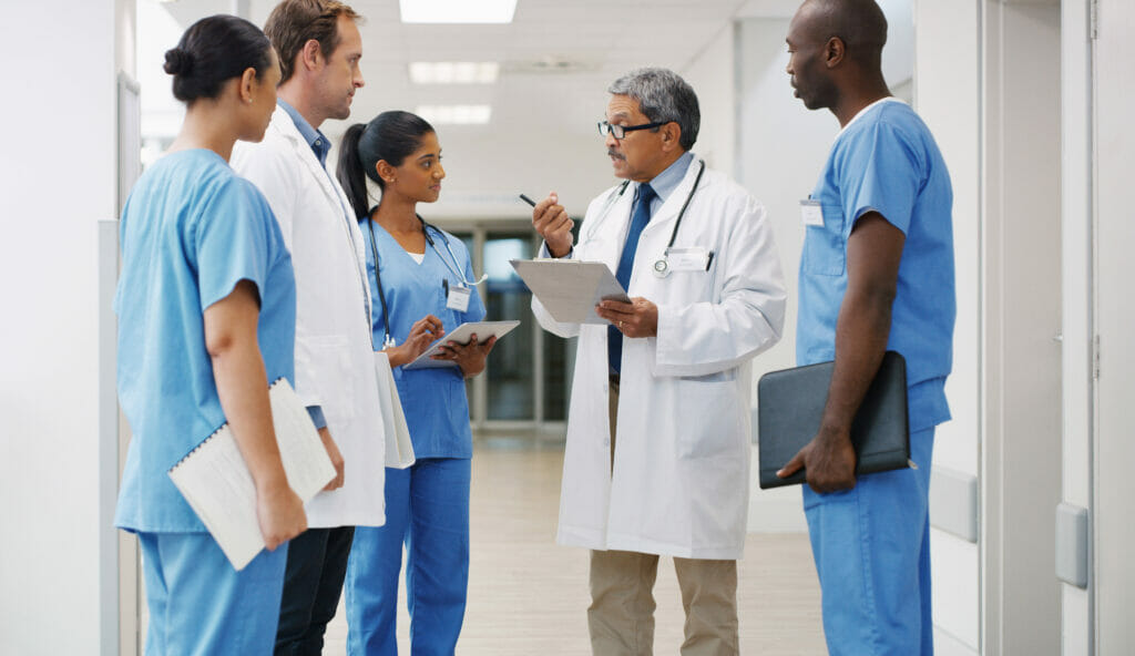 A group of diverse doctors and nurses discuss DEI initiatives.